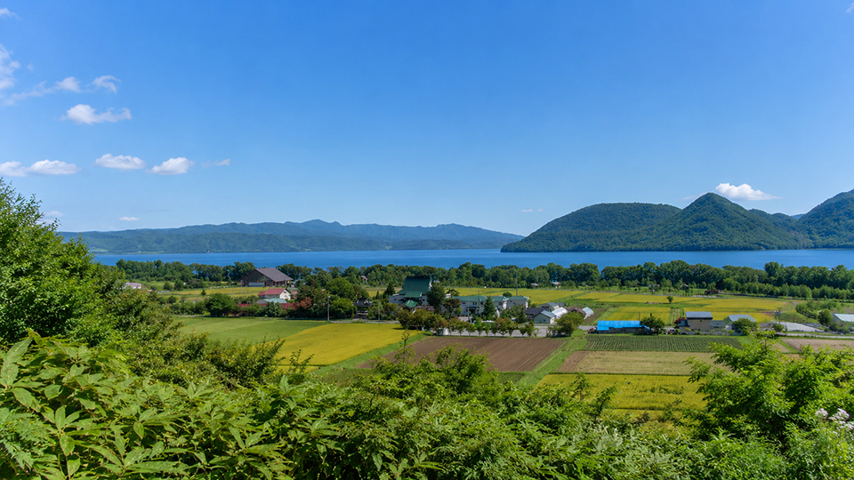 小原山荘の高台から田園と洞爺湖、中島、対岸の山並みを望む景色